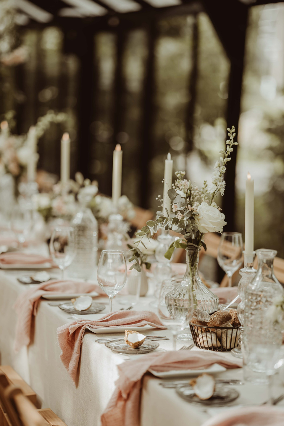 een tafel gedekt voor een bruiloft met kaarsen en bloemen