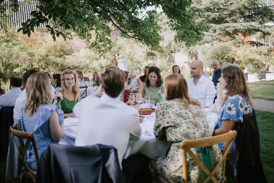 mensen die aan een tafel zitten in een tuin