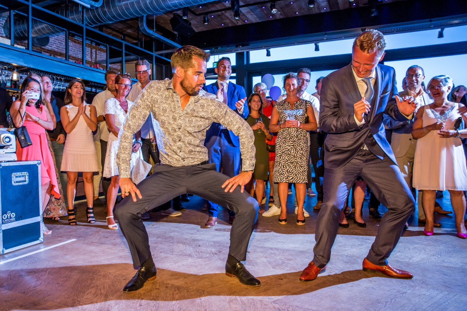 twee mannen dansen op het podium op een bruiloft