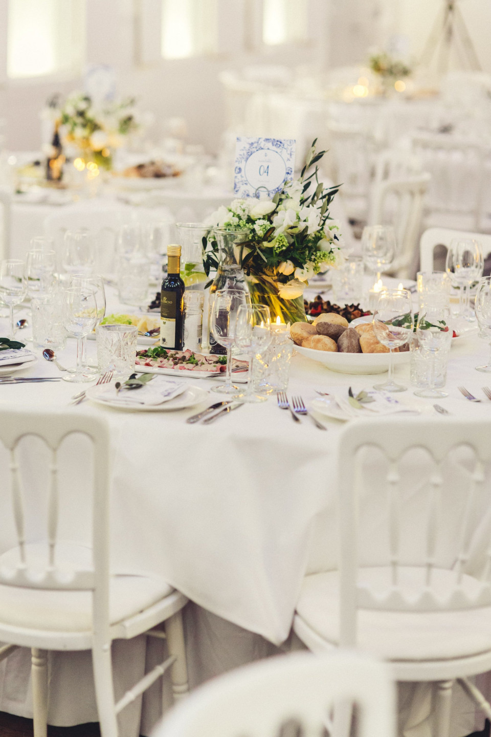 een witte tafel met witte stoelen en een wit tafelkleed