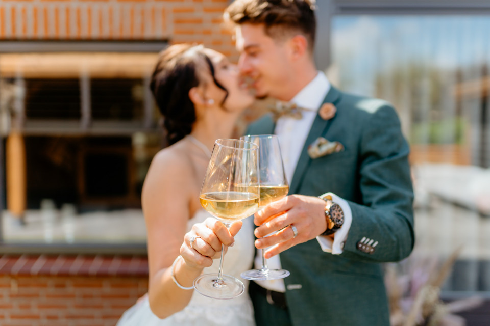 een pasgetrouwd stel dat champagneglazen vasthoudt