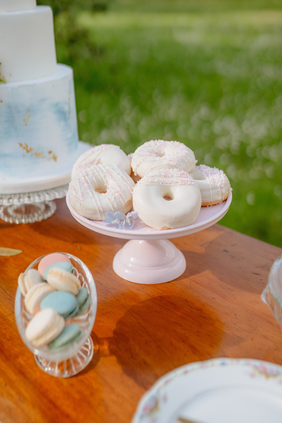 een tafel met een taart, donuts en borden