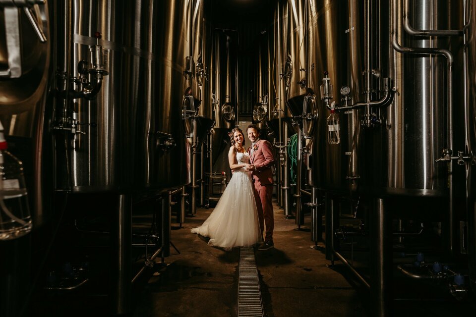 een bruid en bruidegom die in het midden van een rij tanks staan