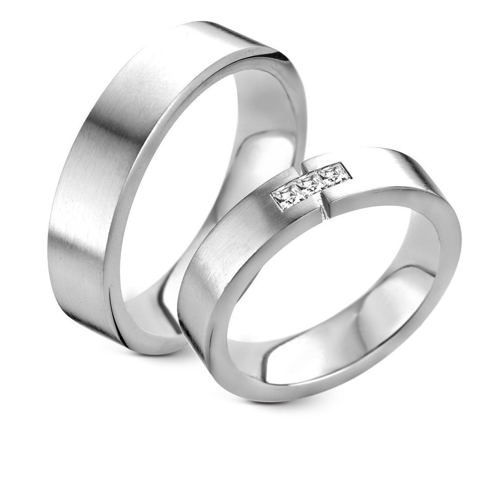 twee trouwringen met diamanten op een witte achtergrond