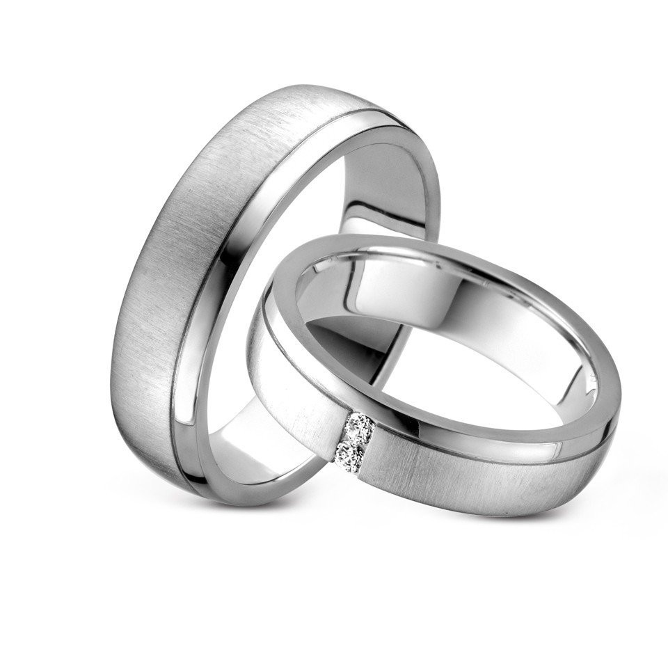 twee trouwringen met diamanten op een witte achtergrond