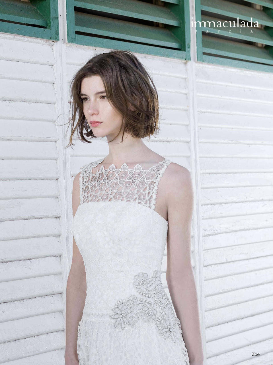 een vrouw in een witte trouwjurk staande voor een groene deur