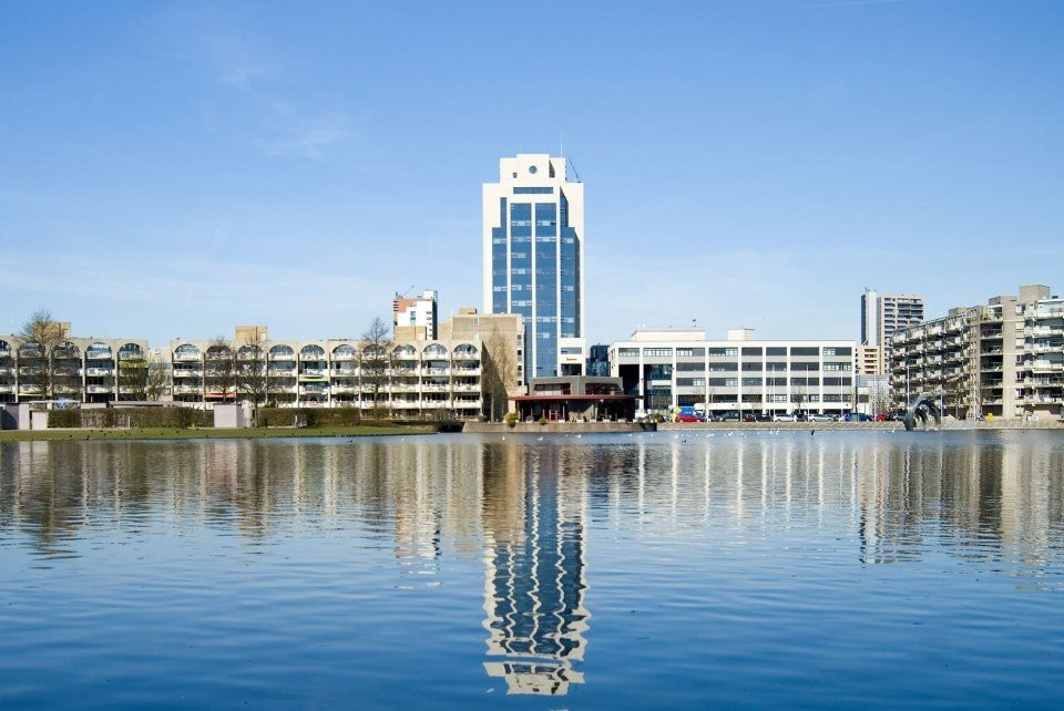 een groot gebouw met een klokkentoren weerspiegeld in het water