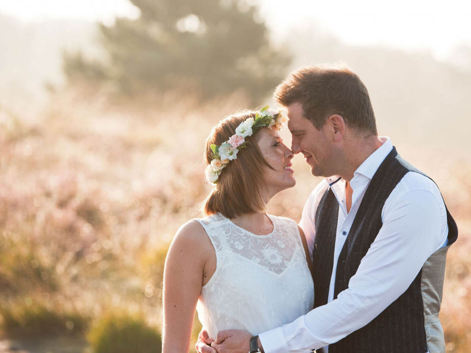 een bruid en bruidegom omhelzen elkaar in het grasveld