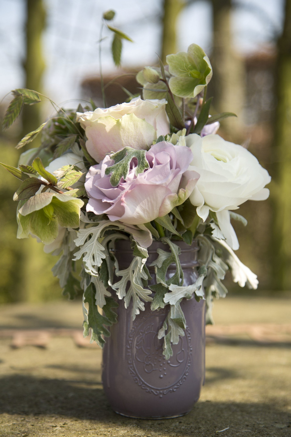 een paarse vaas met bloemen op een tafel